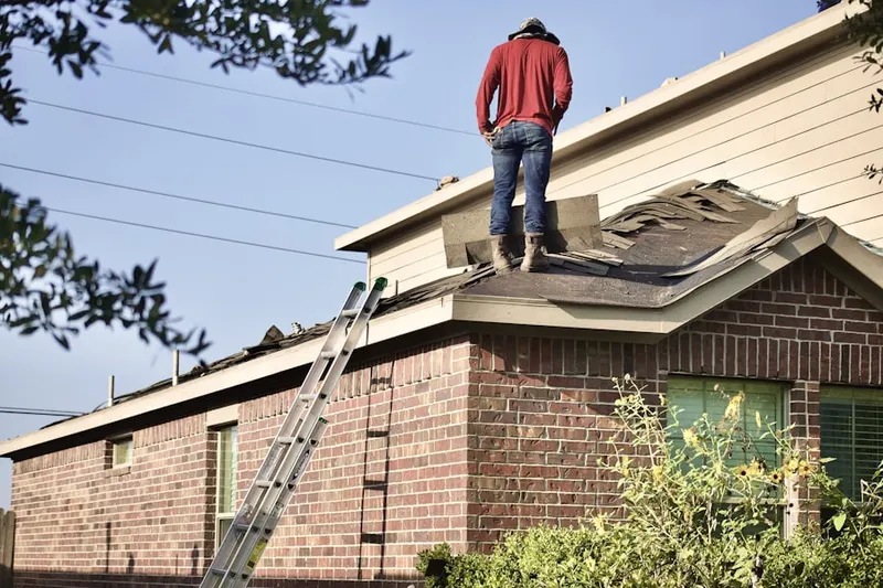 Professional roofer working on a residential roof in Cedar
